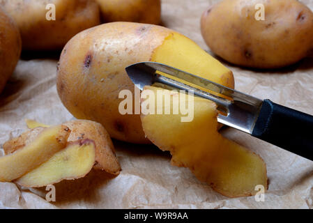 Peeling Kartoffel mit Sparschäler Stockfoto