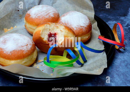 Berliner Pfannkuchen mit Luftschlangen, angebissen Stockfoto