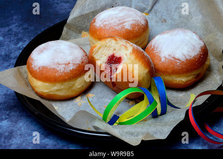 Berliner Pfannkuchen mit Luftschlangen, angebissen Stockfoto