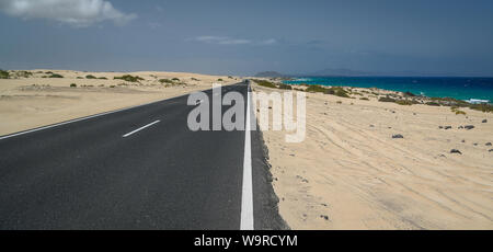 Natürliche Landschaft mit herrlichen Dünen und Asphalt auf Fuerteventura, Naturpark Corralejo, Kanarische Insel in Spanien. Sommer exotischen Urlaub Postkarte f Stockfoto