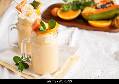 Hausgemachten Smoothie mit tropischen Früchte: Mango, Banane, Ananas, Papaya in Glas Marmeladenglas. Gesund saftig Vitamin drink Stockfoto