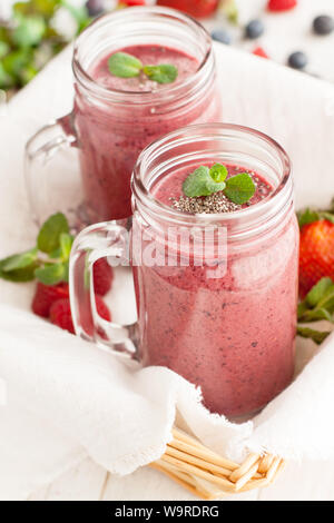 Berry mix Schokolade potein Smoothies im Marmeladenglas auf hellen Hintergrund Stockfoto