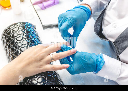 Weibliche Nagelstudio, Maniküre, durch die Zusammenarbeit mit dem Nagelstudio. Das Konzept der Schönheit Professionelle Nagelpflege Stockfoto