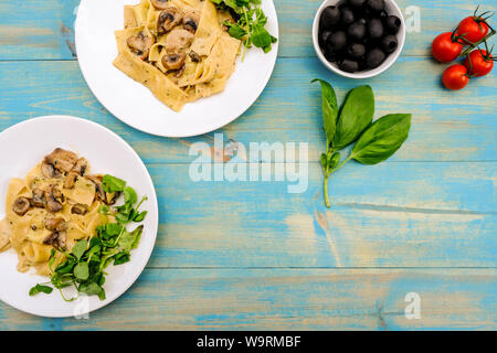 Im italienischen Stil Vegetarisches Pilz Pappardelle Mahlzeit mit einem frischen grünen Salat Im Sommer Stockfoto