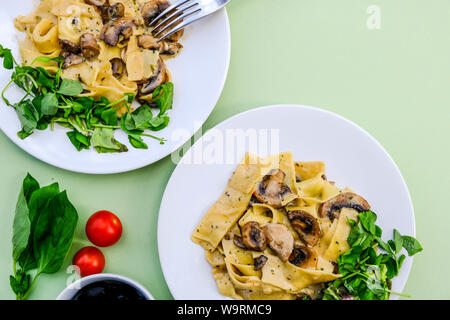 Im italienischen Stil Vegetarisches Pilz Pappardelle Mahlzeit mit einem frischen grünen Salat Im Sommer Stockfoto