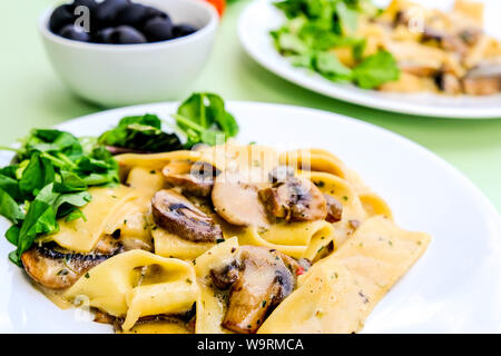 Im italienischen Stil Vegetarisches Pilz Pappardelle Mahlzeit mit einem frischen grünen Salat Im Sommer Stockfoto