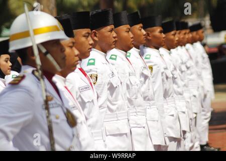 Madiun, Indonesien. 15 Aug, 2019. Mit Studenten zusammen, Personal der Indonesischen Nationalen Streitkräften (TNI) und der indonesischen Polizei (Polri), während in der Ausbildung für Bewerber der Flagge des Heirloom Kraft [Paskibraka Kandidat] auf dem Platz der Stadt von Madiun, Donnerstag, 15. August 2019 zu erhöhen. Die Kandidaten der Paskibraka sind die Durchführung einer sauberen Probe' Training. Credit: Pacific Press Agency/Alamy leben Nachrichten Stockfoto