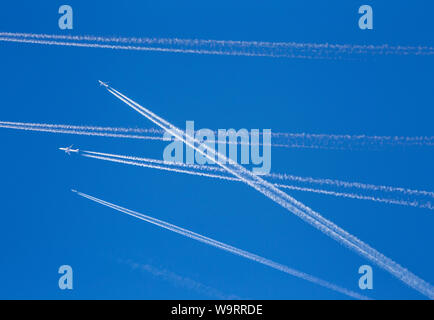 Eine Menge Passagier Flugzeuge, die in der Luft, besetzt Air Traffic, Reisen Hochsaison beginnt Konzept. Weiße Flächen gegen den blauen Himmel. Foto Manipulation. Stockfoto