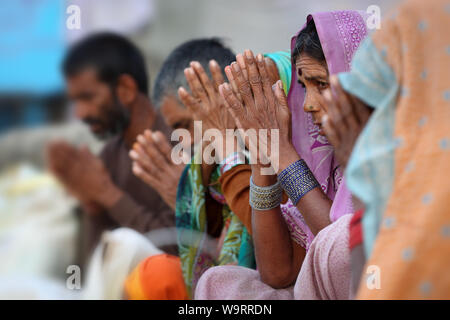 Fromme hinduistische Pilger beten an den Ghats des heiligen Flusses Narmada in Maheshwar, Indien Stockfoto