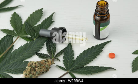 Cannabis Öl, Blätter und Knospen sind am weißen Tisch. Marihuana als Medizin. Hanf ist ein Konzept von Kräutermedizin Stockfoto