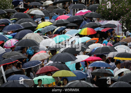Cheonan, Südkorea. 15 Aug, 2019. 15.August 2019 - Cheonan, South Korea-People holding Sonnenschirme sehen Sie hier einen TV-Bildschirm während der Veranstaltung für den 74. Jahrestag der Unabhängigkeit Koreas Tag an der Halle der Unabhängigkeit Koreas in Cheonan, Südkorea, am Donnerstag, 15 August, 2019. Quelle: Bloomberg über Pool/ZUMA Draht/Alamy leben Nachrichten Stockfoto