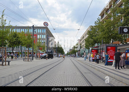 Mannheim, Deutschland - Juli 2019: Straßenbahn Titel durch die Innenstadt von Mannheim mit verschiedenen Geschäften und Menschen auf warmen Sommertag führenden Stockfoto