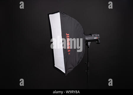 Professionelle softbox über schwarzen Hintergrund. Ein dunkles Schwarz studio Softbox 70 bis 90 cm auf Metall Stativ. Fotografische Technik. Ausrüstung für Professional Stockfoto