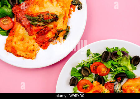 Im italienischen Stil Spinat und Ricotta gefüllte Ravioli Essen mit schwarzen Oliven anda Grüner Salat Stockfoto