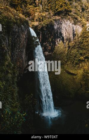 Schöne Aufnahme eines Wasserfalls in einer Klippe umgeben von Moos auf Felsen Stockfoto