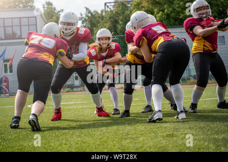 In voller Länge Foto von Athleten Frauen spielen American Football auf grünen Rasen Stockfoto