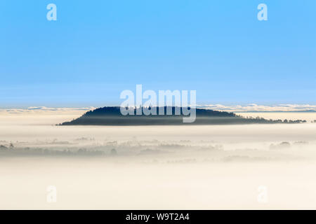 Nebeliger morgen Ansicht mit einem Berg über dem Nebel Stockfoto