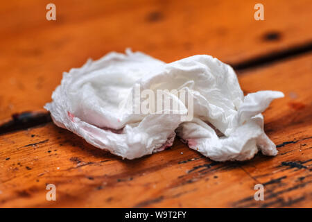 Dirty zerknitterte Serviette auf orange Holztisch Stockfoto