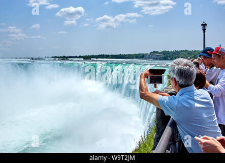 NIAGARA FALLS, Kanada - 25. JULI 2019: Leute, die selfie über Niagara Falls an einem schönen, sonnigen Tag. Kanadische anzeigen. Niagara Falls sind drei Stockfoto