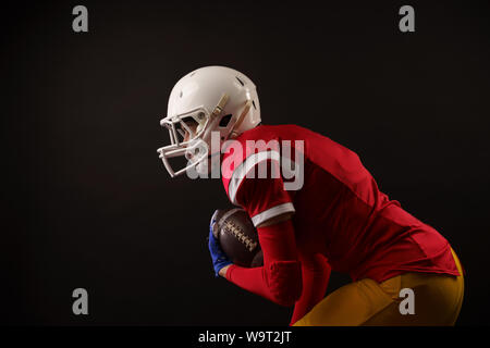 Foto von Frau mit rugby ball, Helm auf leeren schwarzen Hintergrund Stockfoto