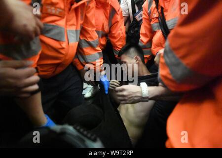 (190815) - HONGKONG, 15 August, 2019 (Xinhua) - Eine verletzte Tourist ist von den Sanitätern aus einer Einkesselung von gewaltbereiten Autonomen am Hong Kong International Airport in South China Hong Kong, Aug 13, 2019 begleitet. Zwei Monate auf, der Eskalation der Gewalt in Hongkong hat einen schweren Tribut von der sozialen Ordnung. Gewalttätige radikale verpflichtet, Vandalismus, blockiert der Fahrspuren, belästigt urbanen Pendler und Brände an. Viele haben sich für eine Bremse auf die krasse Gewalt und für die Ordnung wiederhergestellt werden. (Xinhua) Stockfoto