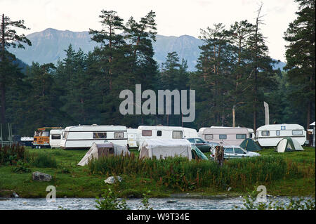 Trailer Camp am grünen Tal im Wald. Glade voller Reisemobile. Stockfoto
