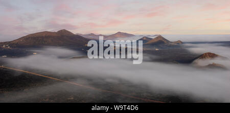 Vulkanlandschaft Lanzarotes eingehüllt in Morgennebel Stockfoto