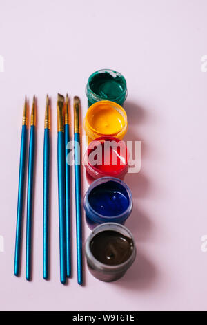 Pinsel mit Farben auf der rosa Hintergrund Stockfoto