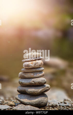 Fluss Steine locker auf dem Felsen. Pyramide der Fluss Steine auf der anderen Stockfoto