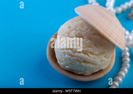 Vanille Eis wie Perle in Muschel auf blauem Hintergrund Deep Sea Pearl Necklace Platz für Text Stockfoto