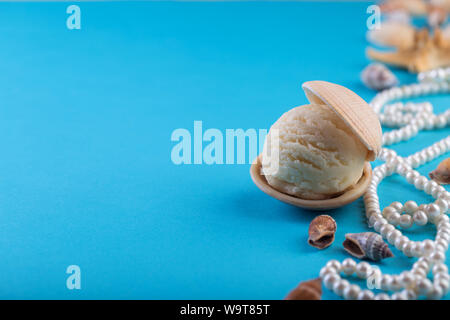 Vanille Eis wie Perle in Muschel auf blauem Hintergrund Deep Sea Pearl Necklace Platz für Text Stockfoto