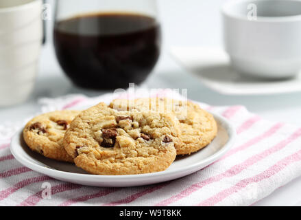 Die Chocolate Chip Cookies auf Teller und Macadamia für Kaffeepause eingestellt Stockfoto