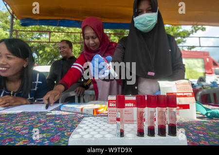 Palu, Sulawesi, Indonesien. 15 Aug, 2019. PALU, Sulawesi, Indonesien - 15. August: Gesundheit Arbeiter organisieren Blutprobe ist ein jugendlich für das Human Immunodeficiency Virus (HIV)-Test in Palu, Sulawesi, Indonesien am 15. August 2019. Der Test, der durch die lokale Gesundheit Service initiiert wurde, sollen Jugendliche HIV leiden und Prävention für die Übertragung so früh wie möglich zu erkennen. Credit: Sijori Images/ZUMA Draht/Alamy leben Nachrichten Stockfoto