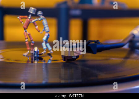 Perm, Russland - November 4, 2018: Zwei lustige kleine menschliche Figuren, etwa von Widerständen und Transistoren zusammen geschweißt, Tanz auf einer rotierenden vinyl Reco Stockfoto