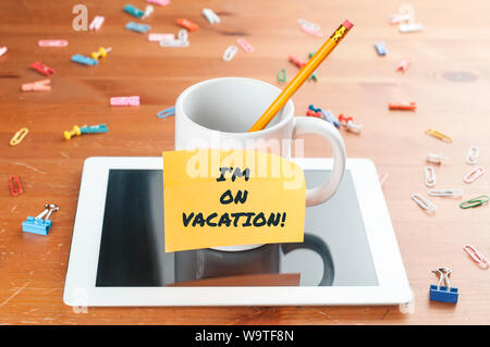 Konzept: eine Schale mit einem Bleistift innen auf ein Tablett mit einer Notiz und der Text, den ich im Urlaub Stockfoto