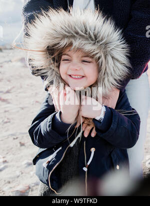 Porträt einer Mutter umarmte ihre Tochter trägt ein fake Fell Hooded Jacket, Palm Springs, Kalifornien, USA Stockfoto