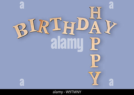 Happy Birthday mit Holz Buchstaben auf blauem Hintergrund geschrieben Stockfoto
