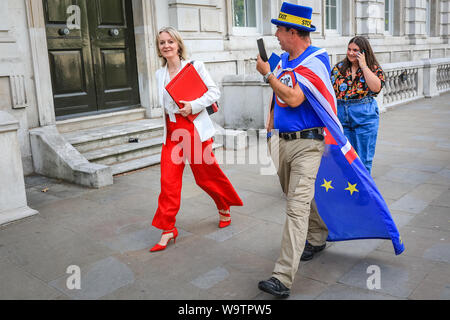 London, Großbritannien. 15 Aug, 2019. Elizabeth (Liz) Truss, MP, Staatssekretär für internationalen Handel und der Präsident des Board of Trade, verlässt das Cabinet Office in Whitehall, surrouded von Anti-Brexit Demonstranten, darunter Westminster "Mr. Stop Brexit' Steven Bray. Credit: Imageplotter/Alamy leben Nachrichten Stockfoto