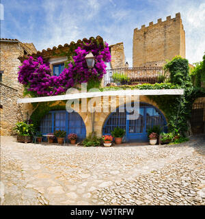 Die hellen lila Bougainvillea an den Wänden eines typischen Peratallada Haus kontrastieren mit dem blauen Lackierung und weichen, roten Stein arbeiten Stockfoto