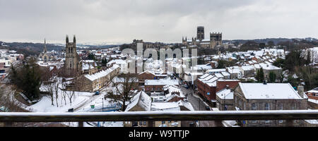 Durham, England, UK - Februar 1, 2019: Schnee bedeckt die Dächer der Häuser und Gebäude im Stadtbild von Durham, darunter das Schloss und die Cathedra Stockfoto