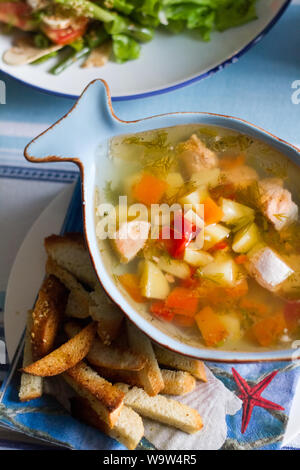 Ansicht von oben Fischsuppe in der Platte in Form von Fisch und Cracker neben einer Platte, selektiven Fokus Stockfoto
