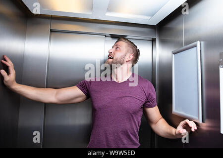 Man Platzangst Leiden gefangen im Aufzug Schreien Stockfoto