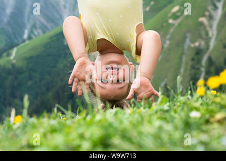 Kleines Mädchen hing kopfüber in die Berge Stockfoto