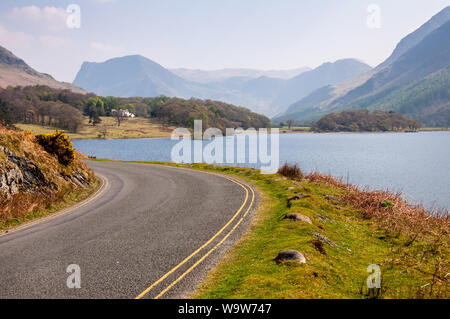 Einen schmalen Feldweg Winde um die Ufer des Lake Crummock Water unter den Bergen des englischen Lake District. Stockfoto