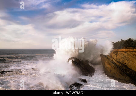 Massive Welle explodiert gegen die Sandsteinfelsen bei Shore Acres Park an der südlichen Küste von Oregon. Stockfoto