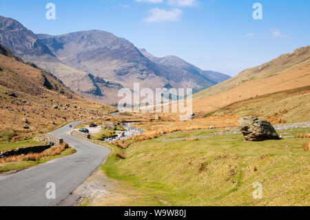 Einen schmalen Feldweg schlängelt sich durch das Tal Stock von Honister Pass unter den Bergen des englischen Lake District. Stockfoto