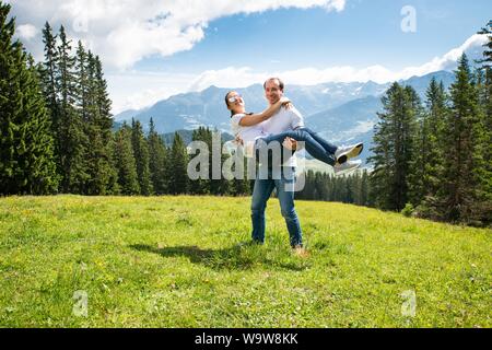 Mann, der Frau in den Bergen mit schöner Aussicht im Hintergrund Stockfoto