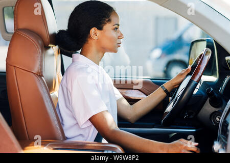 Seitenansicht der Frau schalten Auto mit Handschaltung. Junge weibliche Fahrer freuen. Stockfoto
