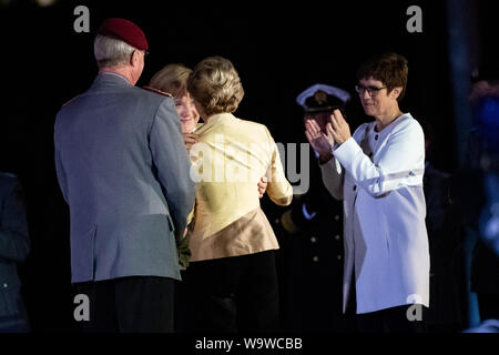 15. August 2019, Berlin: Bundeskanzlerin Angela Merkel (CDU, undercover) umfasst Ursula von der Leyen (2. von rechts, CDU), ehemaliger Verteidigungsminister, in der Gegenwart von Annegret Kramp-Karrenbauer (r, CDU), Verteidigungsminister und General Eberhard Zorn, der Generalinspekteur der Bundeswehr, nach der Leyen des Wachbataillon und das Personal Musik Korps der Bundeswehr feierlich Abschied mit einem großen hähnen Schlaganfall. Der grosse Zapfenstreich ist das höchste militärische Zeremoniell der Bundeswehr, mit denen der Bundespräsident, Bundeskanzler und Verteidigungsminister verabschieden werden. P Stockfoto