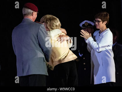 15. August 2019, Berlin: Bundeskanzlerin Angela Merkel (CDU, undercover) umfasst Ursula von der Leyen (2. von rechts, CDU), ehemaliger Verteidigungsminister, in der Gegenwart von Annegret Kramp-Karrenbauer (r, CDU), Verteidigungsminister und General Eberhard Zorn, der Generalinspekteur der Bundeswehr, nach der Leyen des Wachbataillon und das Personal Musik Korps der Bundeswehr feierlich Abschied mit einem großen hähnen Schlaganfall. Der grosse Zapfenstreich ist das höchste militärische Zeremoniell der Bundeswehr, mit denen der Bundespräsident, Bundeskanzler und Verteidigungsminister verabschieden werden. P Stockfoto